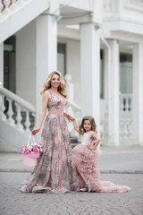 Beautiful slender woman and her little daughter,having fun together outdoors in the spring,on a...
