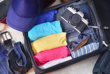 Topview open travel bag which have clothes and accessories.