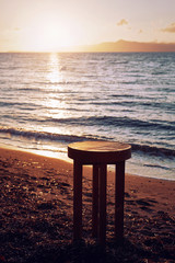 Brown wooden table stool on the beach for background backdrop use