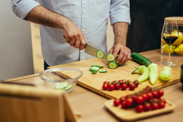 Obraz na płótnie Canvas close up of man cutting vegetables for salad