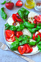 Caprese salad with strawberries. Strawberry salad with basil and mozzarella. Healthy summer salad. Keto summer. Keto diet.