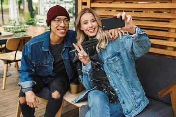 Smiling multhiethnic couple sititng at the cafe outdoors