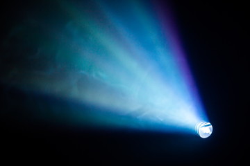 projector spotlight blue color , smoke texture background . light beam screening and glowing for...