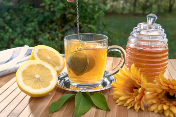 Tea filter ball falling into a glass of hot water.