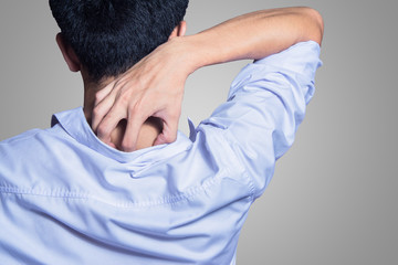 young man hands scratching the itch on the back with shirt