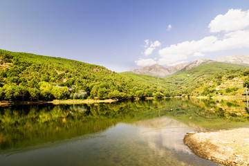 beautiful panoramic view of a lake surrounded by green mountains