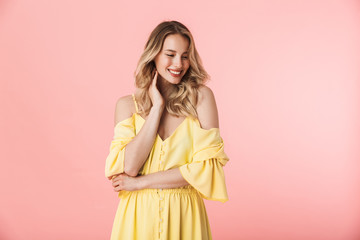 Happy young blonde woman posing isolated over pink wall background.