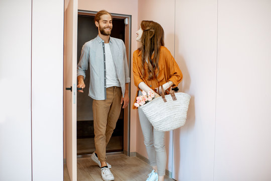 Beautiful Young Couple Coming Home, Walking Together In The Pink Corridor Of The Modern Apartment