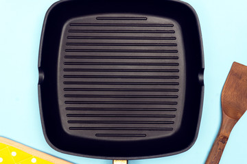 Empty grill pan on bright blue background. Grill food concept