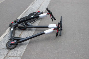 Scooter kicksharing lying on the sidewalk. Electric rental kick scooter in Paris city.