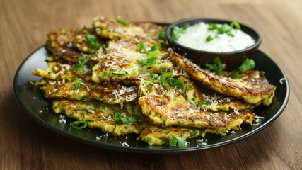 zucchini fritters, vegetarian zucchini pancakes, served with fresh herbs and garlic yogurt sauce.