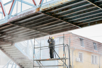 Naklejka premium Sand blasting process Industial worker using sand blasting process preparation cleaning surface on steel before painting