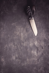 Male Hands with Black Latex Gloves and Knife on Dark Background