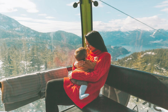 Mother holding her baby son in the gondola of a cable car, Squamish, Canada