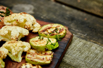 Grilled zucchini and cauliflower vegetable on wooden background . Vegan food. Diet, healthy Picnic. Summer. Top view. Flat lay. Copy space..