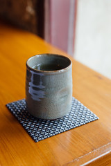 Japanese green tea grey ceramic cup on wooden table.