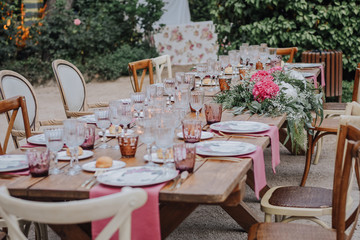 Finca decorada el día de la boda, mesas con tonos rosas y luces en el aire