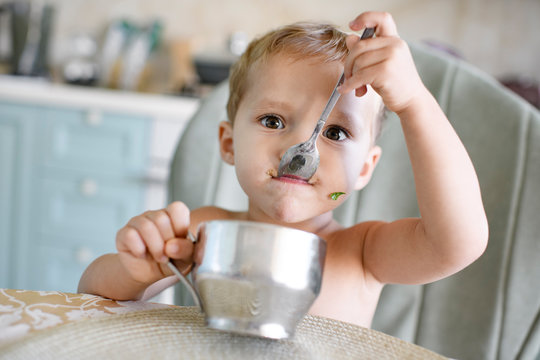 Portrait of little girl eating from metal mug
