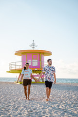 Miami south Beach, youn couple men and woman on the beach during sunrise. Miami beach Floarida