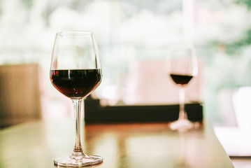 Glass of red wine on table in house. relaxing at home concept.