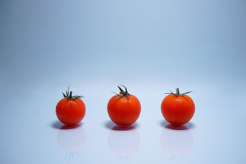 three tomato on blue background.