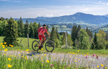 senior woman mountainbiking on a e-mountainbike in early spring, in the Allgaeu Area, a part of the...