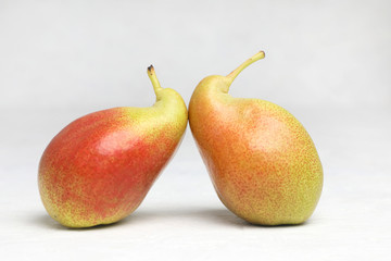 Ugly vegetables , two ripe pears of bizarre shape ,are leaning .  on a white background .