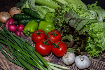 set of fresh vegetables in the dark. vegetarian food on wooden background. vegetable harvest from the garden.