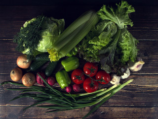 set of fresh vegetables in the dark. vegetarian food on wooden background. vegetable harvest from the garden.