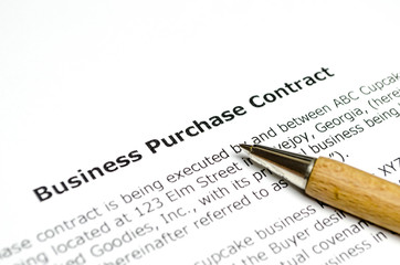 Business purchase contract with wooden pen