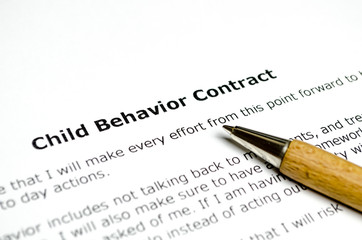 Obraz premium Child behavior contract with wooden pen