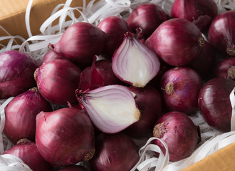 Fresh whole purple onions in the box for packing product