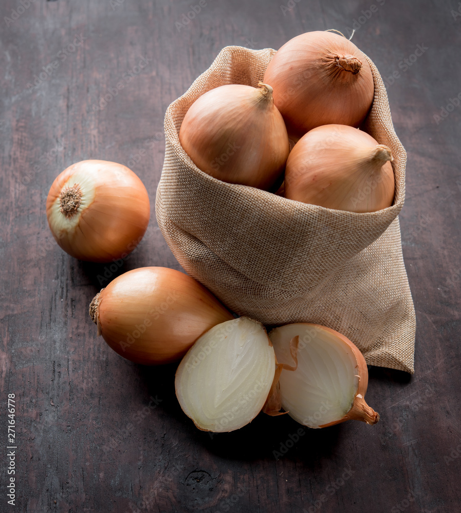 Wall mural fresh onions and one sliced onion on wood table