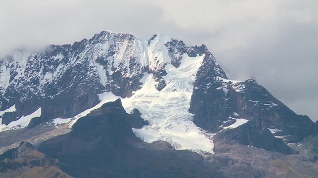 Extreme high-angle close-up still shot of snow white glacier on the peak of black andean mountain, Andes, Peru