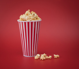 Full red bucket of popcorn against red background