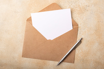 Blank paper in Kraft envelope on a light background. Clean postcard for your signatures. Top view