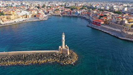 Obraz premium Aerial drone photo of iconic Venetian lighthouse in the entrance of picturesque old port of Chania at sunset with beautiful colours, Crete island, Greece