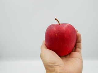 Hand holding fresh red apple that represent fruit for diet and good health care concept, isolated on white background.
