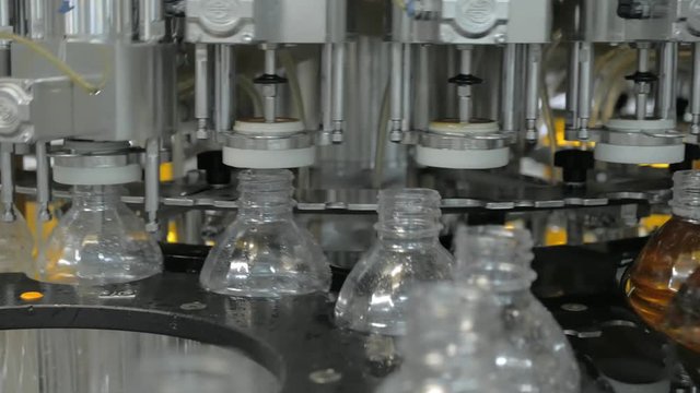 Plastic bottles inside industrial machine conveyor line or belt preparing for filling with drink. Water and juice bottling plant