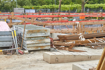 Auf einer großen Baustelle liegen viel Material und Werkzeuge herum.