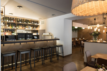 Counter and stools of small bar inside stylish cozy restaurant