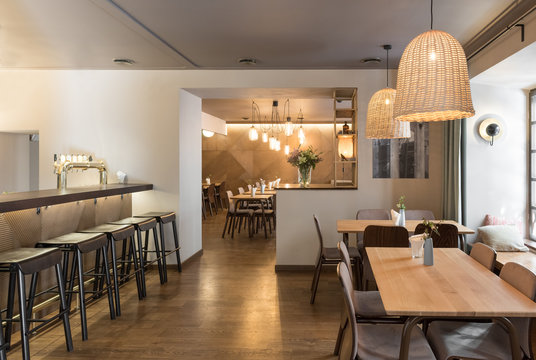 Stylish lamp shining over small tables and comfortable chairs in cozy restaurant