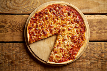 Top view of homemade Italian pizza margherita on old wooden table