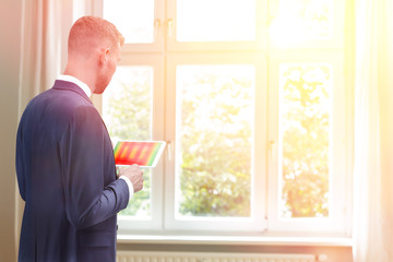 Fototapeta premium Male energy consultant with an thermographic picture of windows on his tablet computer, copy space