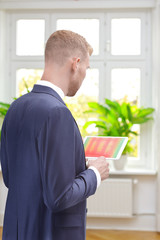 Male energy consultant in a room of an old building with an infrared picture of the windows on his...