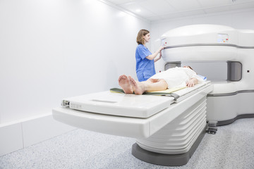 Middle-aged woman and her doctor in an open MRI machine waiting for the test to start