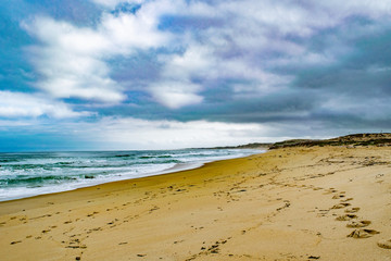 Fototapeta na wymiar Cloudy Skies and Patterns in the Sand