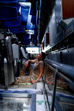 Attractive female soldier looking up while sitting inside modern military transport