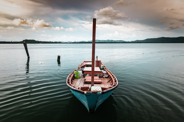 Fishery wooden boat at the shore lake scape.