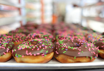 Fresh donuts on display racks at the donut shop.